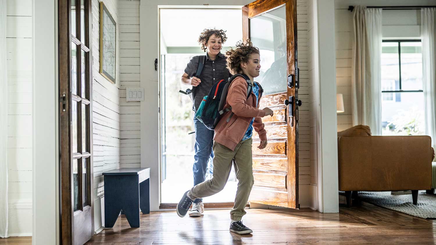 Teenage boys running through the house doorway