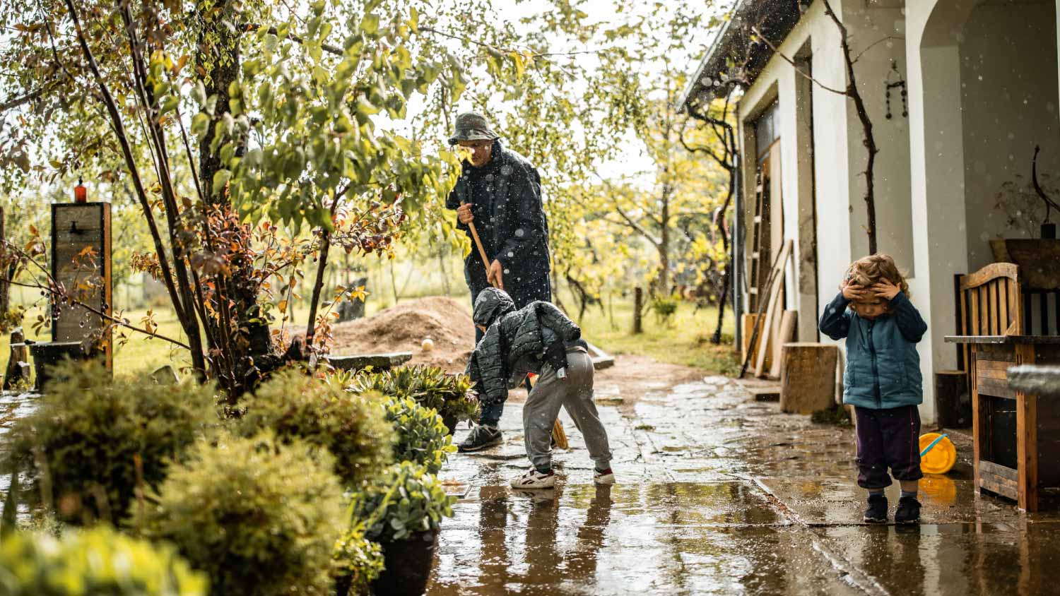 Father and sweeping water from yard