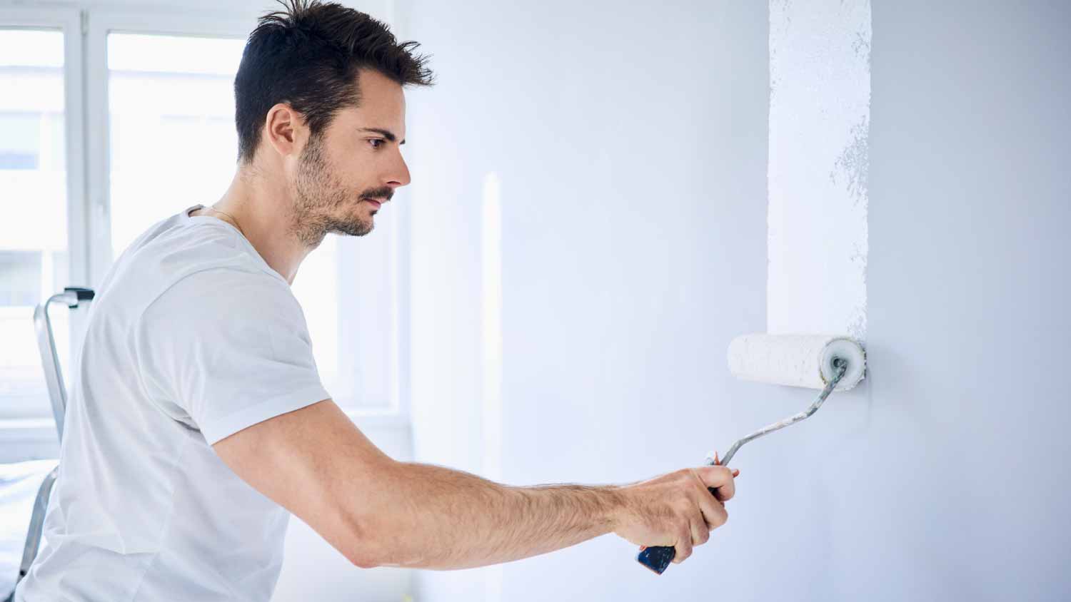 Man painting wall in apartment