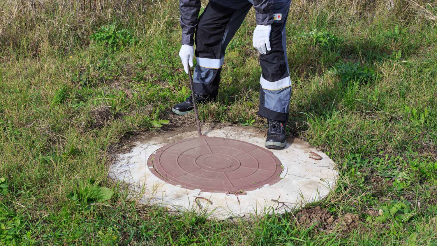 Worker checking septic tank