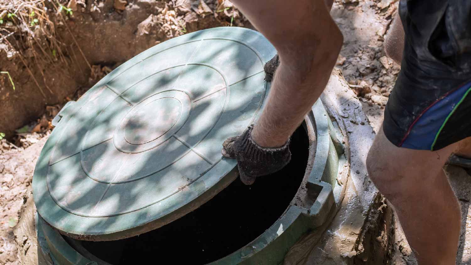A person opening a septic tank