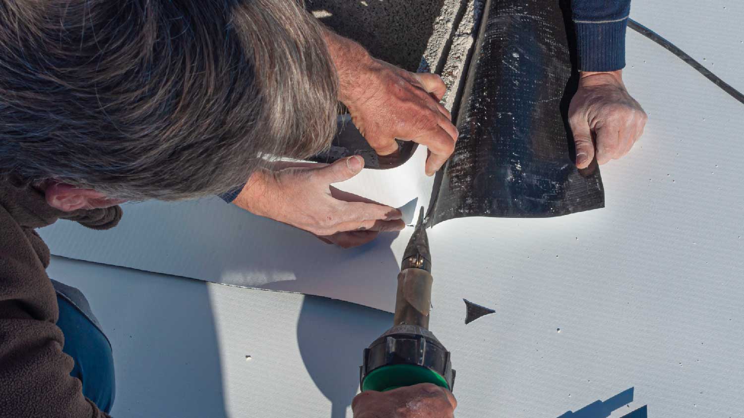 Two persons connecting TPO seams