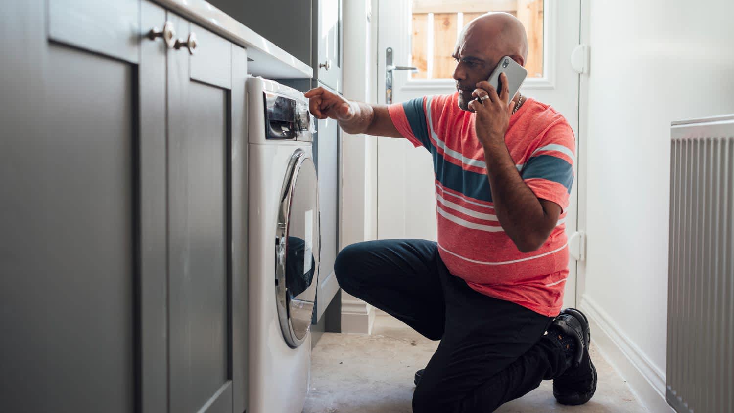 man inspecting his washing machine
