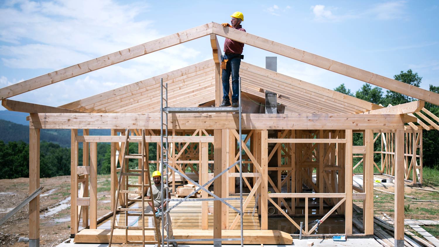 Construction Workers Working On Wooden Roof Of House