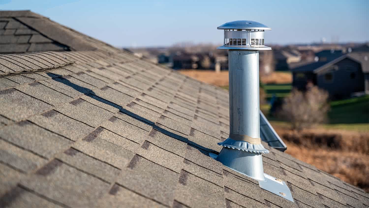 Tall silver vent on house roof.