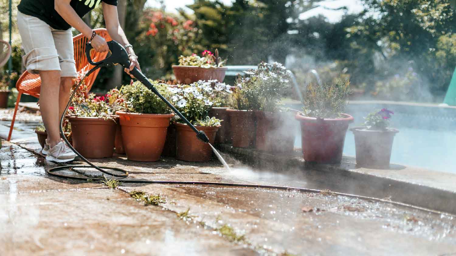 A person pressure washing the patio