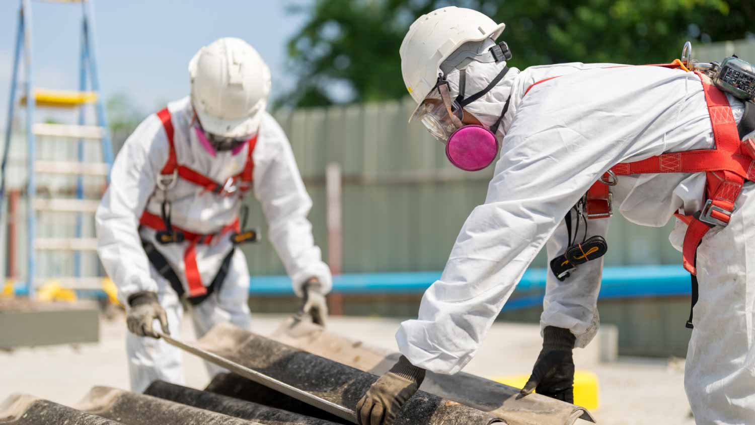 Workers removing asbestos roof tiles