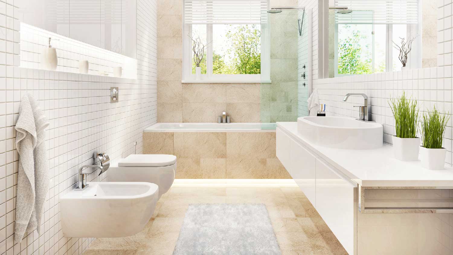 A bright bathroom with a toilet, a bidet and a bathtub
