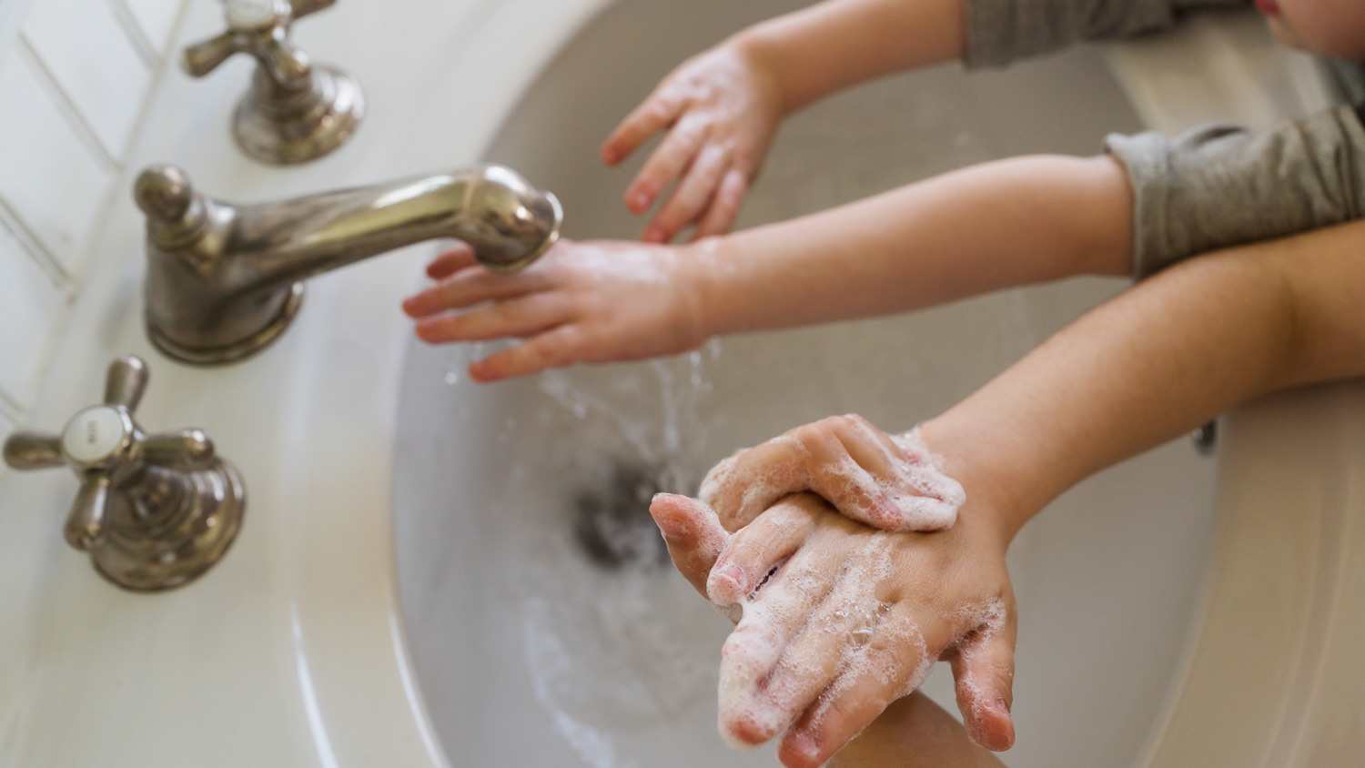 Kids washing hands in sink