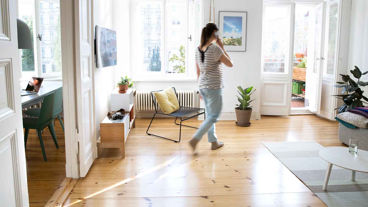 Woman walking in the living room and talking on the phone