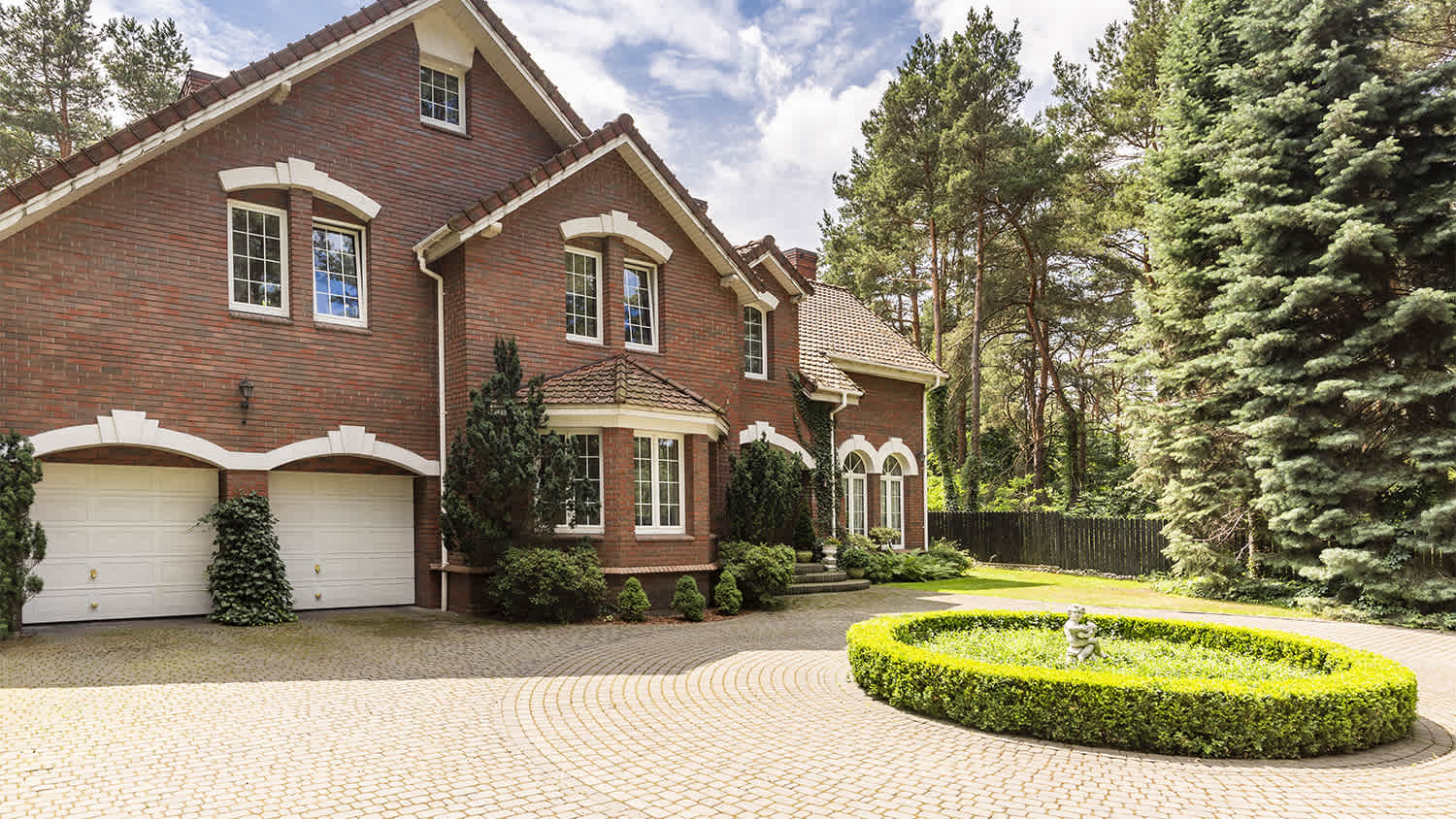 large red brick house with paver driveway