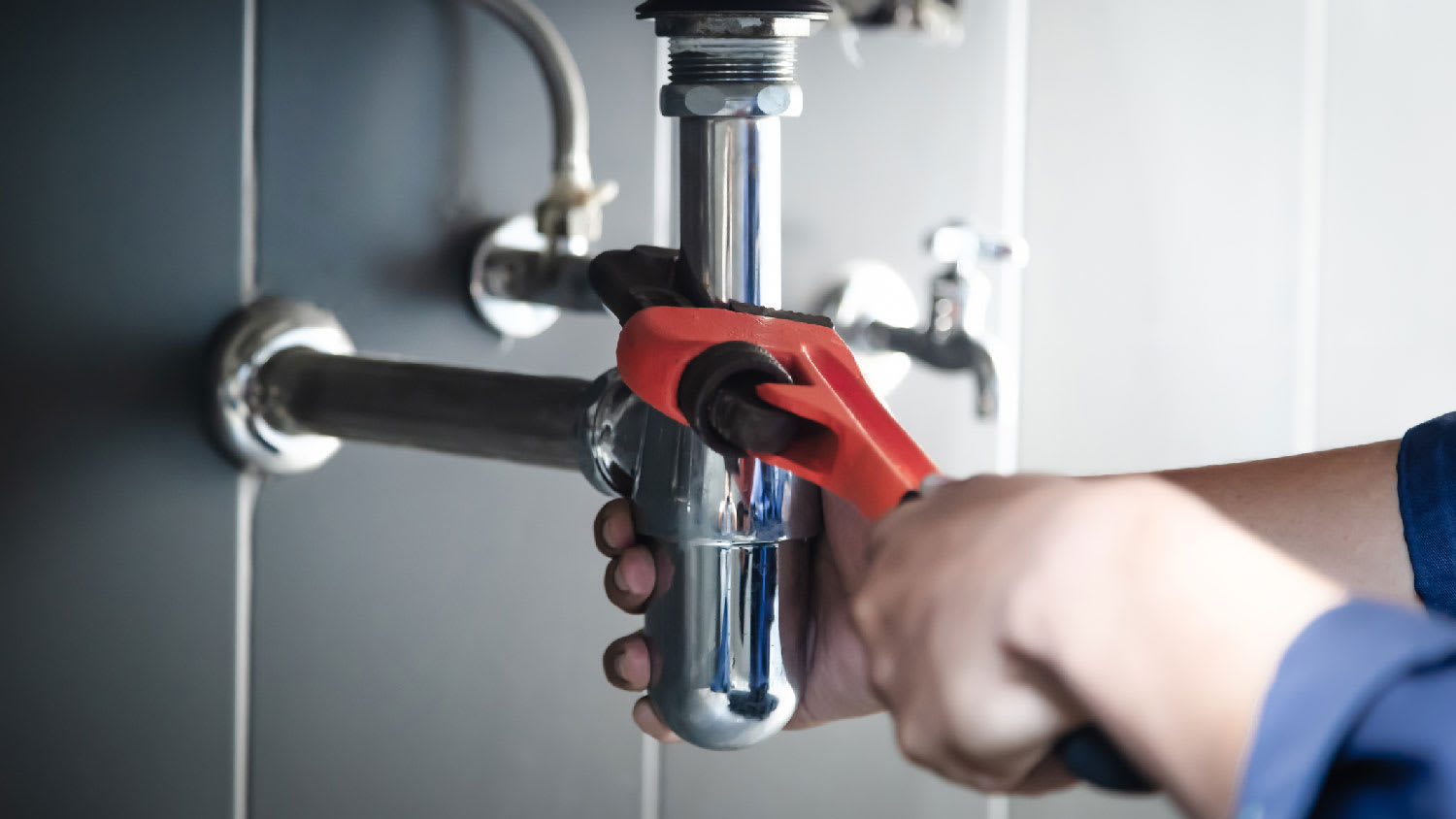 A plumber using a drain on a sink drain pipe