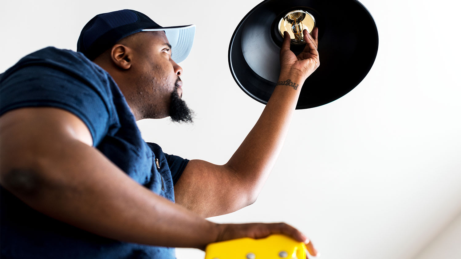 A handyperson changes a light bulb
