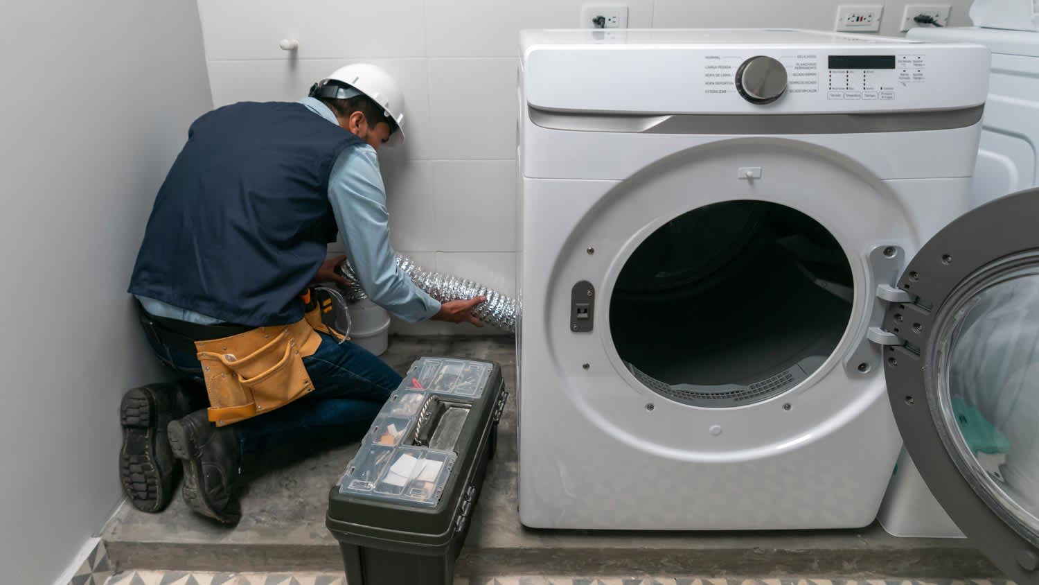 repairman installing gas dryer