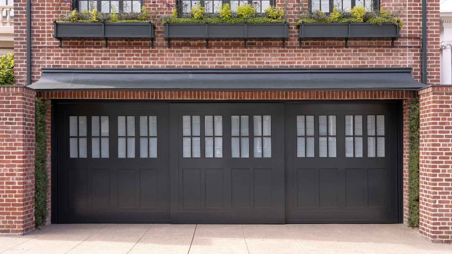 A side sliding garage door in a red brick house