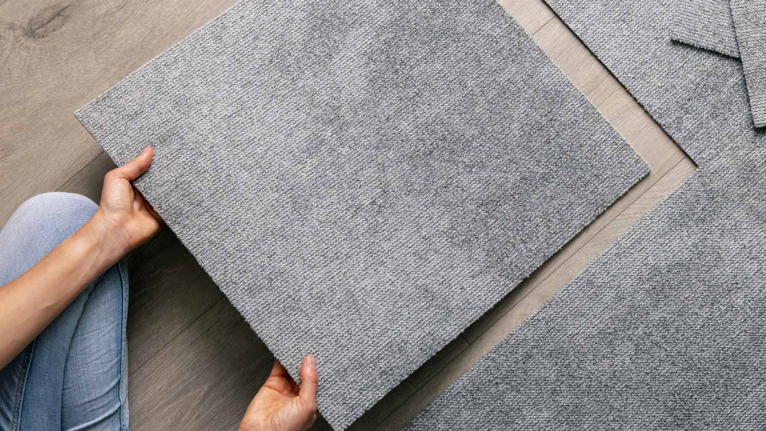 Woman laying carpet tiles