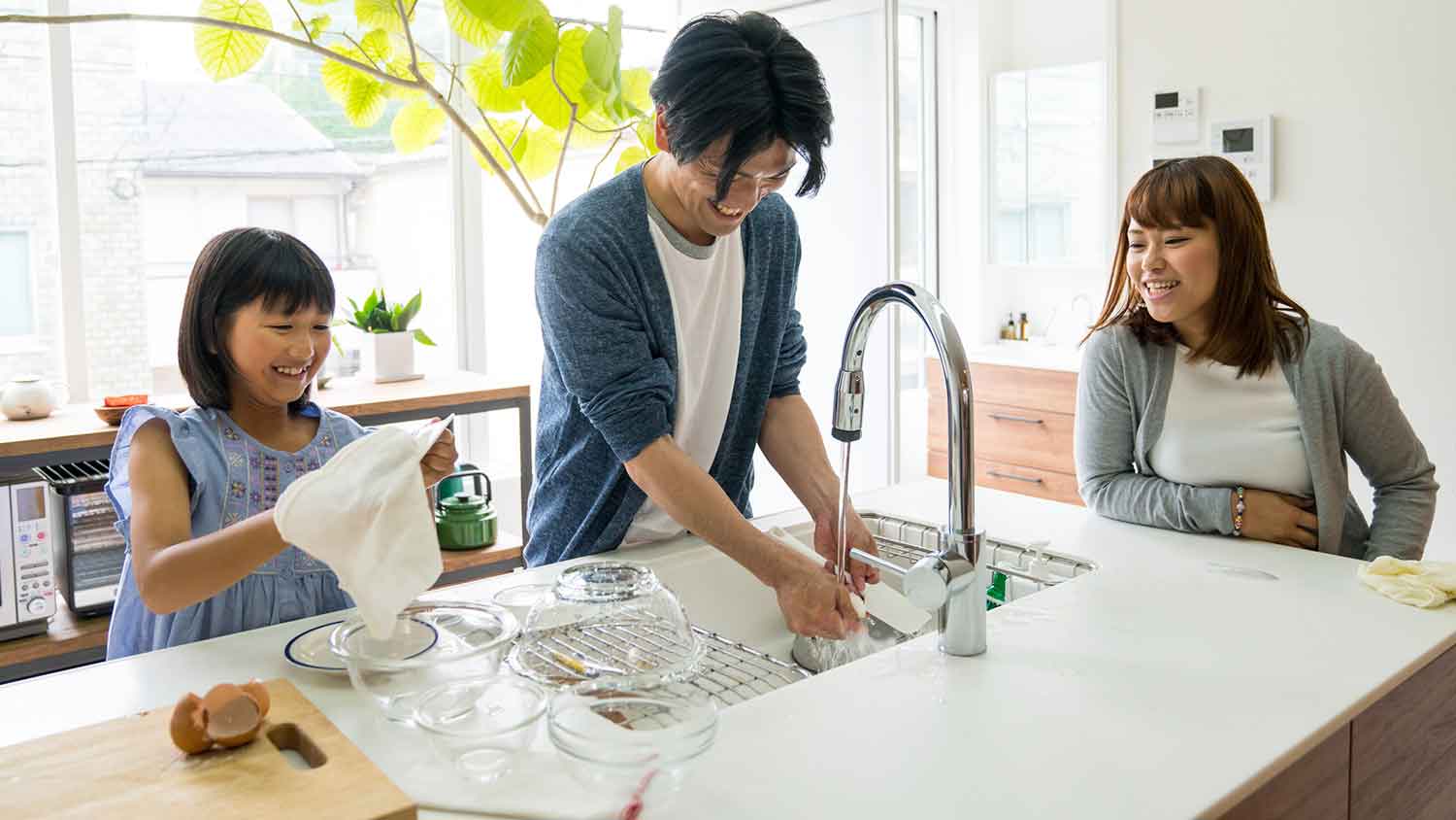 Father and daughter washing dishes at home