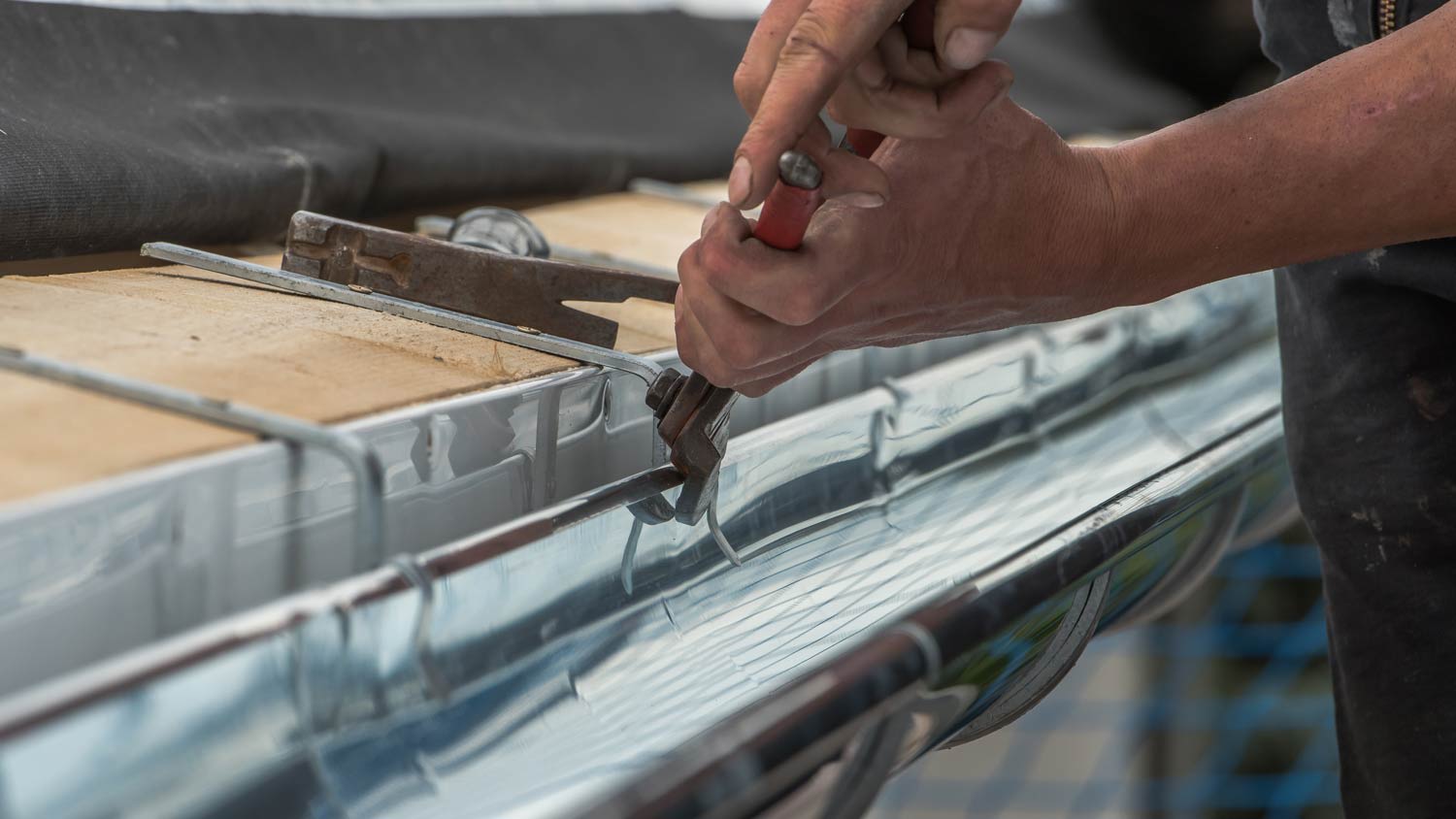 man repairing metal gutter