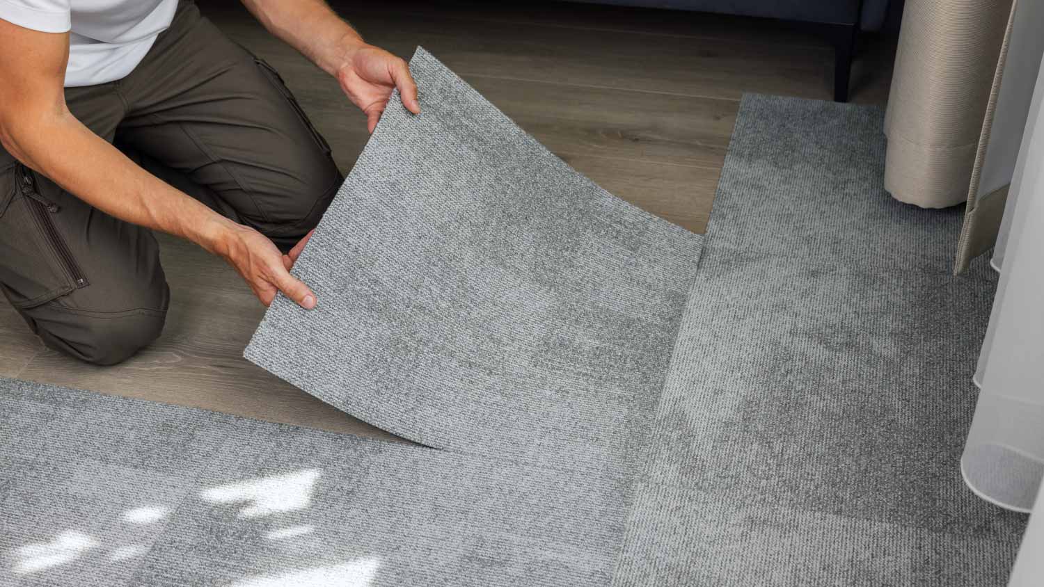 A man installing carpet tiles