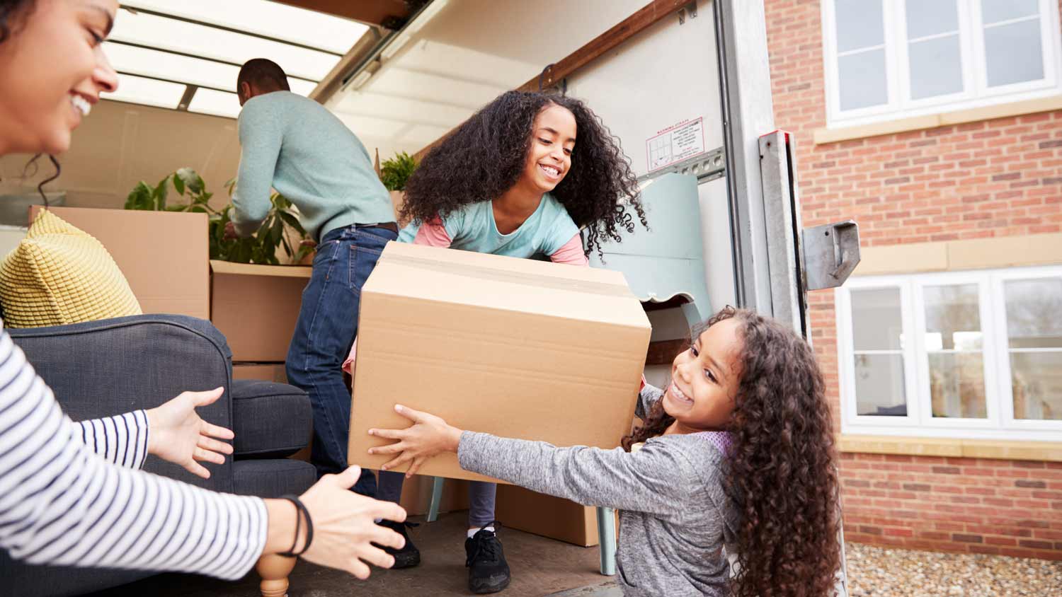 family unloading furniture from truck