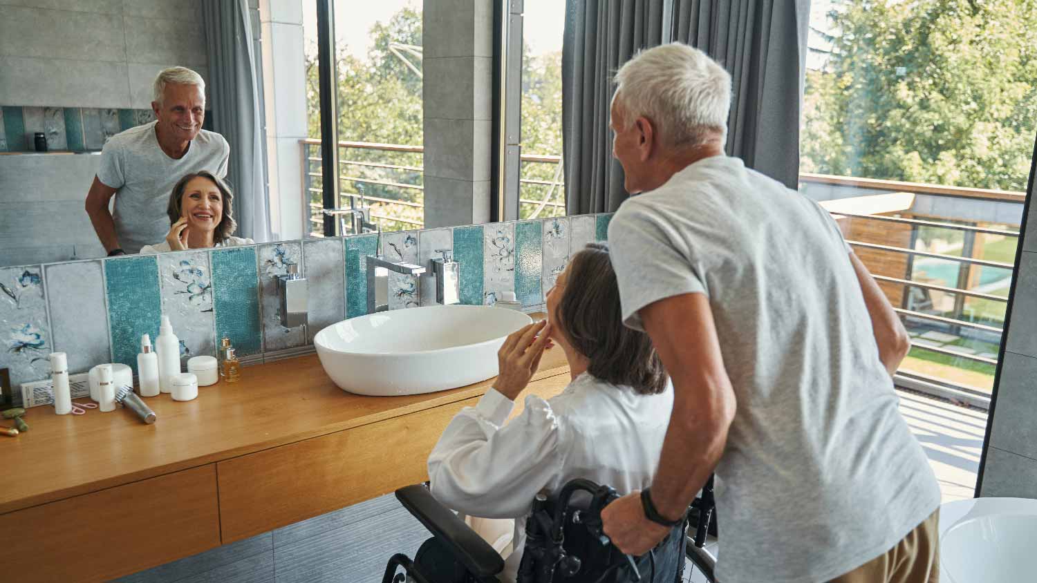 A senior woman on a wheelchair in front of a bathroom sink