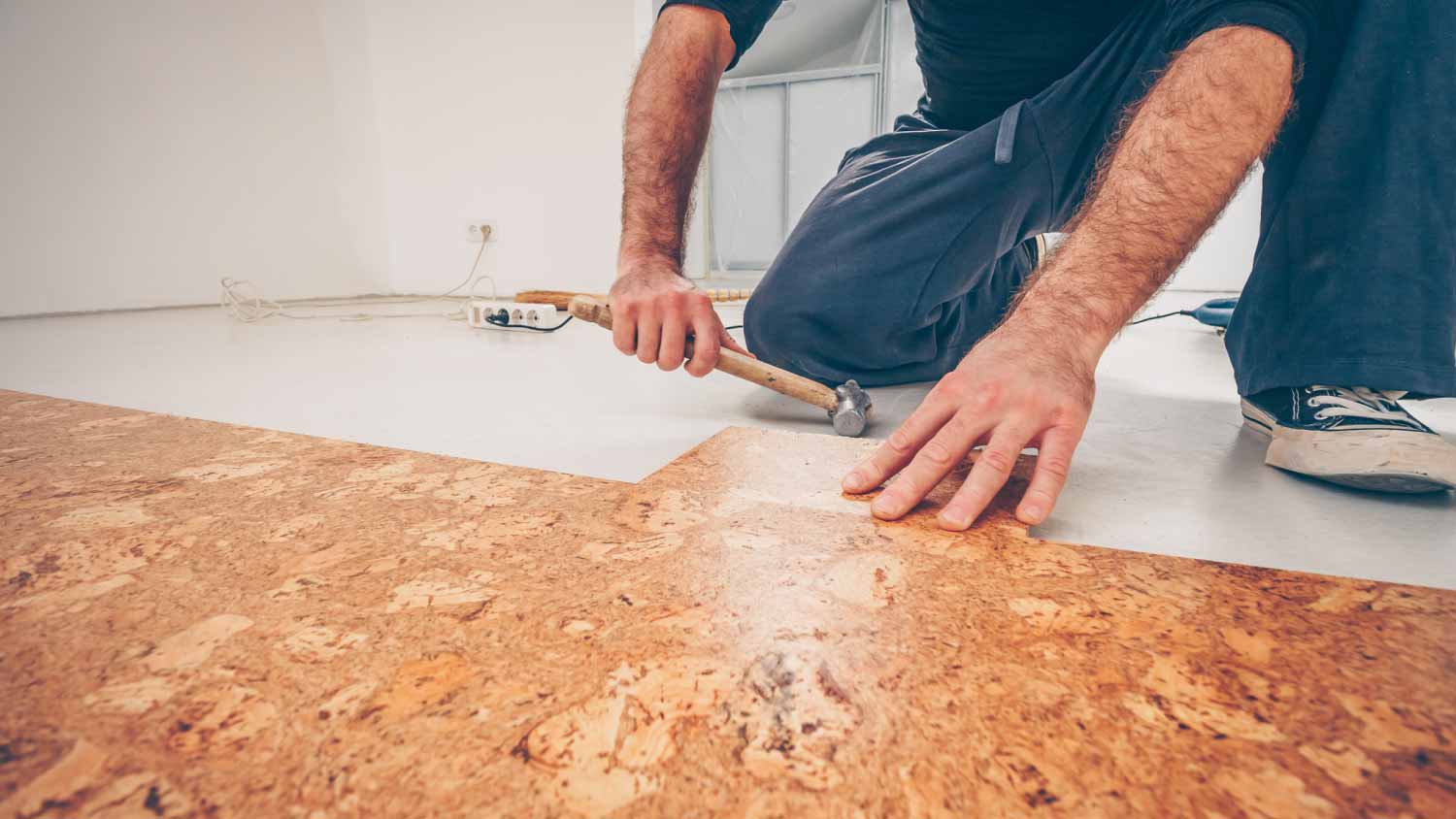 A man installing cork flooring