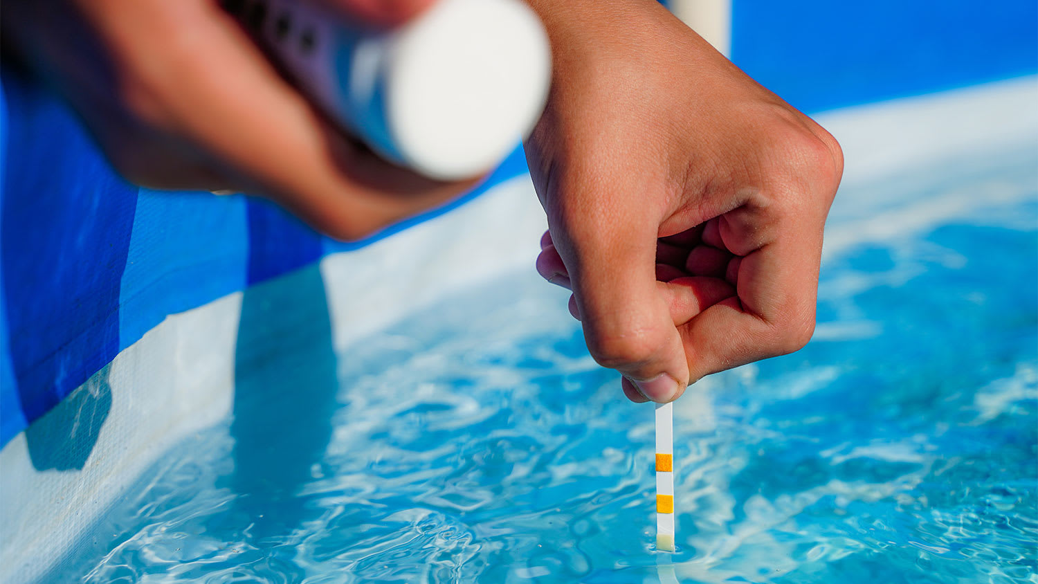 A closeup of someone checking the pH of a swimming pool