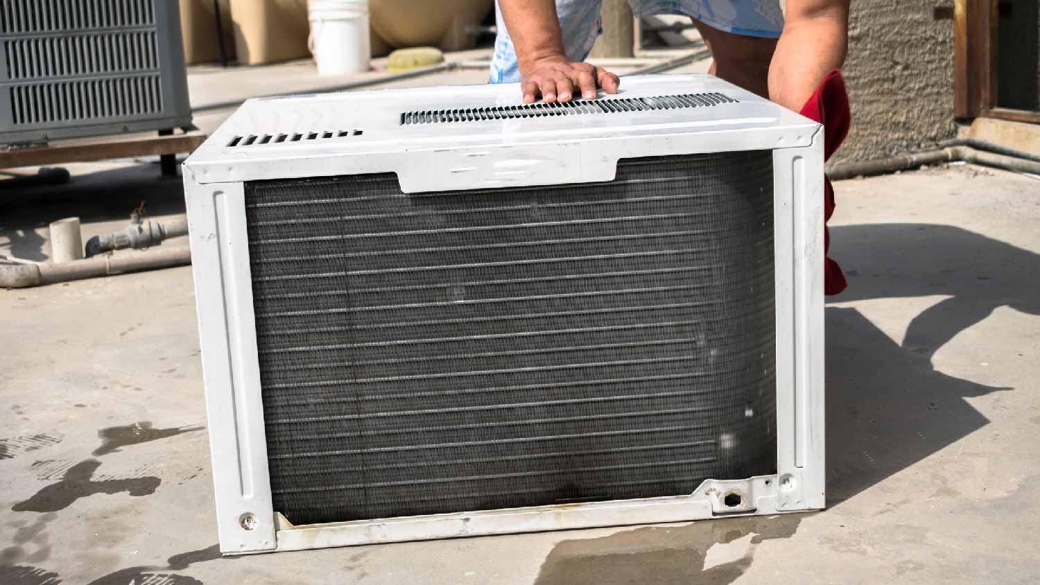 A person installing a window AC