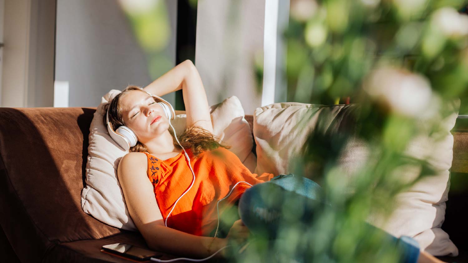 A woman relaxing in the living room while listening to music