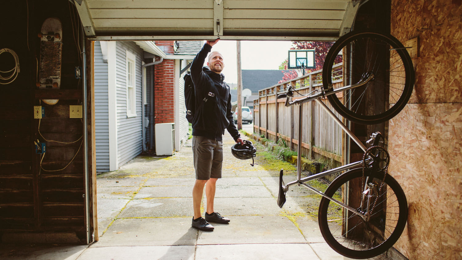 Male commuter with backpack closing garage door