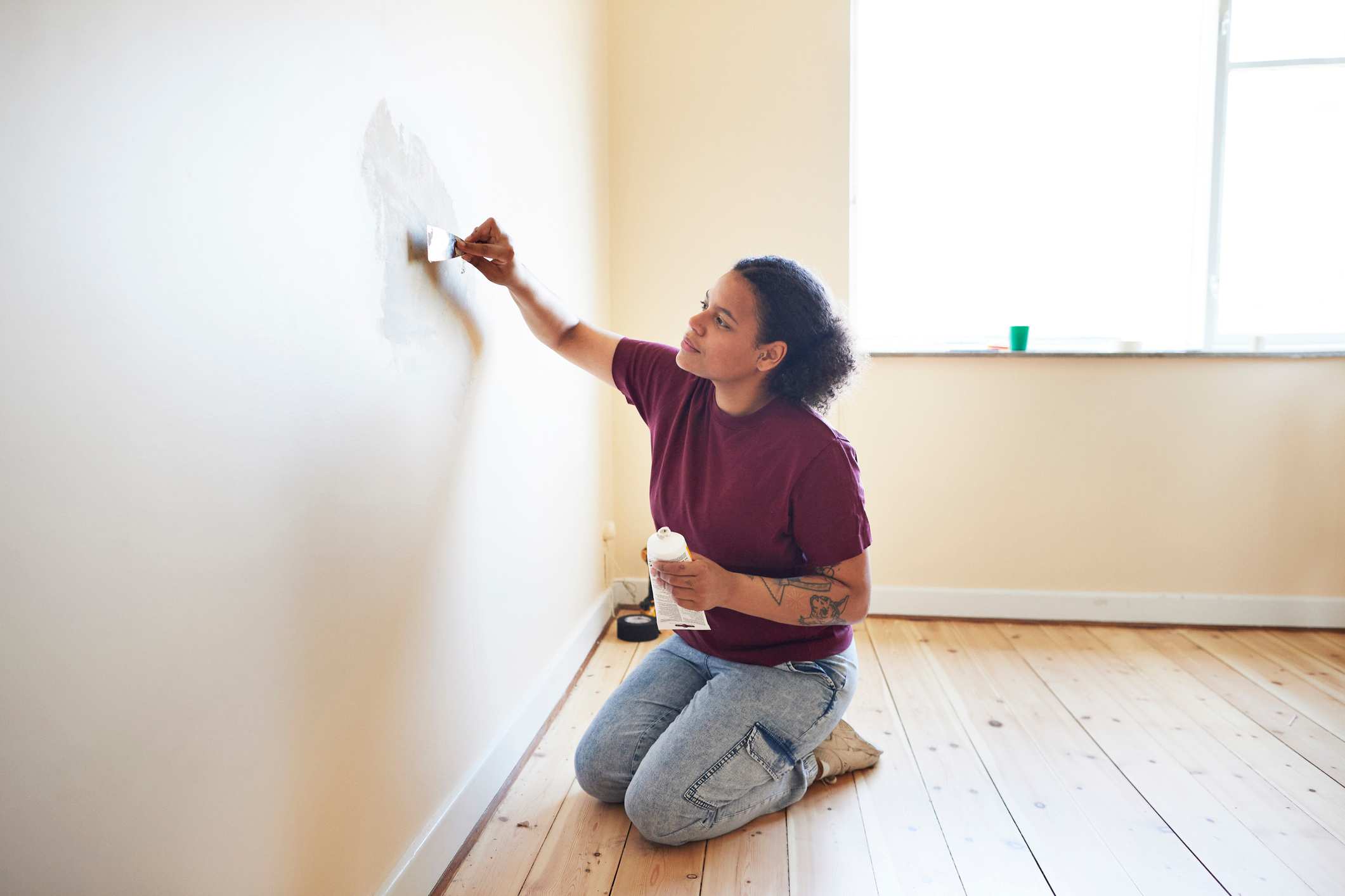 Woman patching up holes on the wall