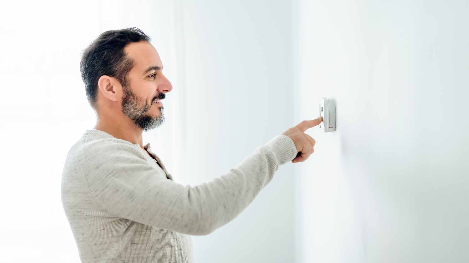 Man setting the thermostat