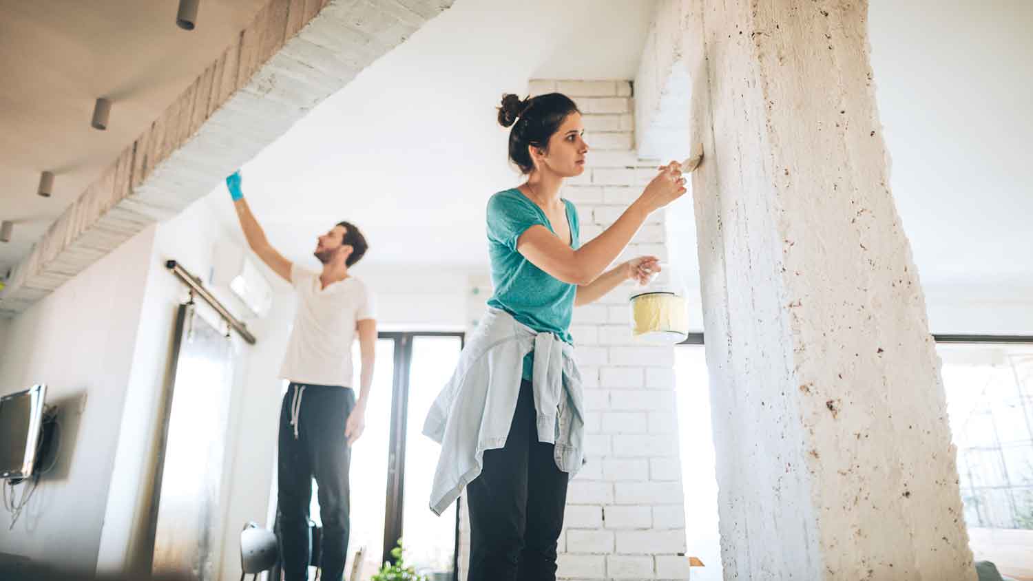 Couple painting apartment interior walls