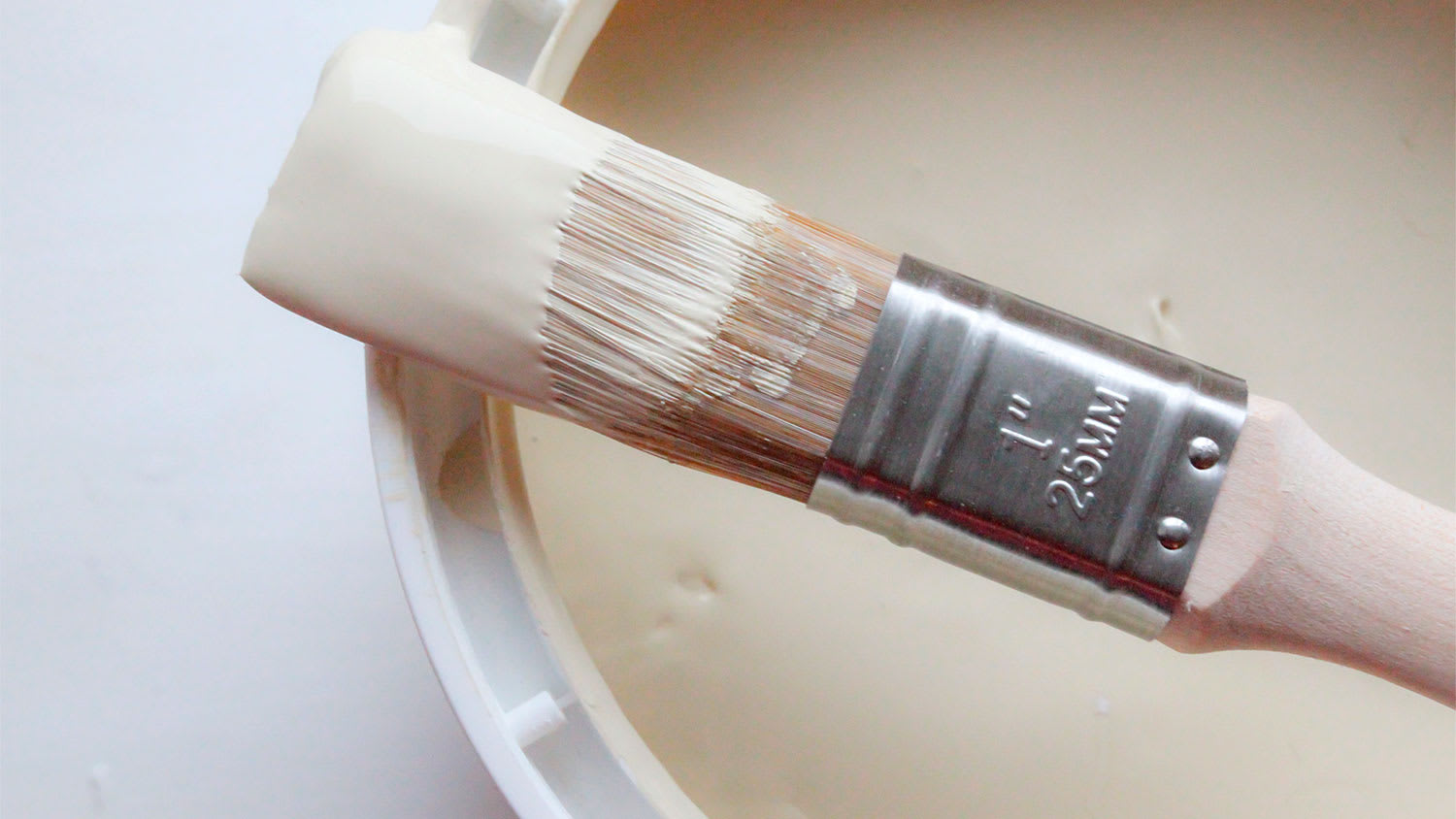 An overhead view of a paintbrush resting on a paint can