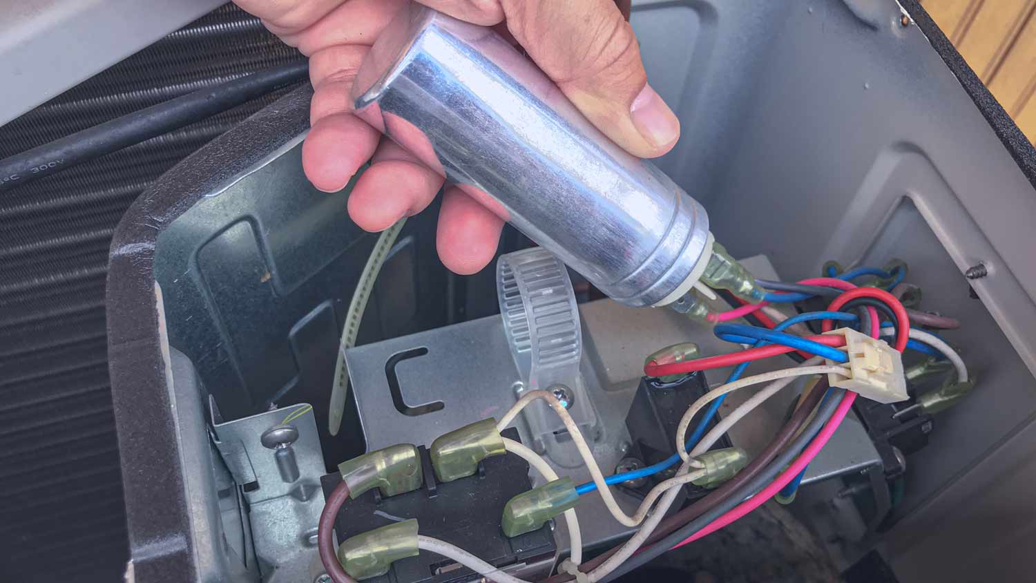 technician repairing ac capacitor