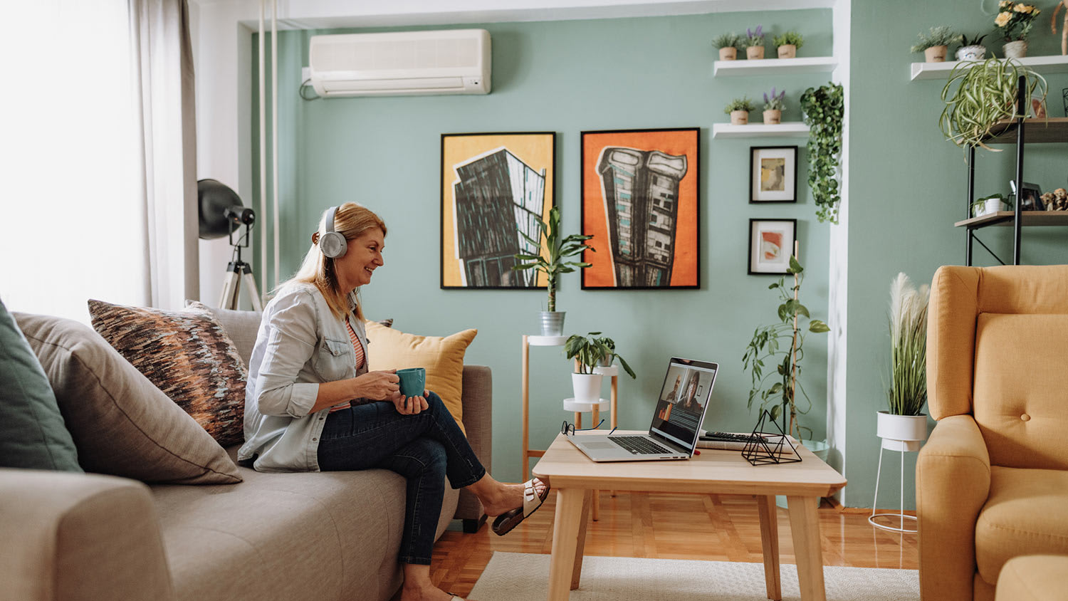 Woman on conference call on couch with mini-split on wall