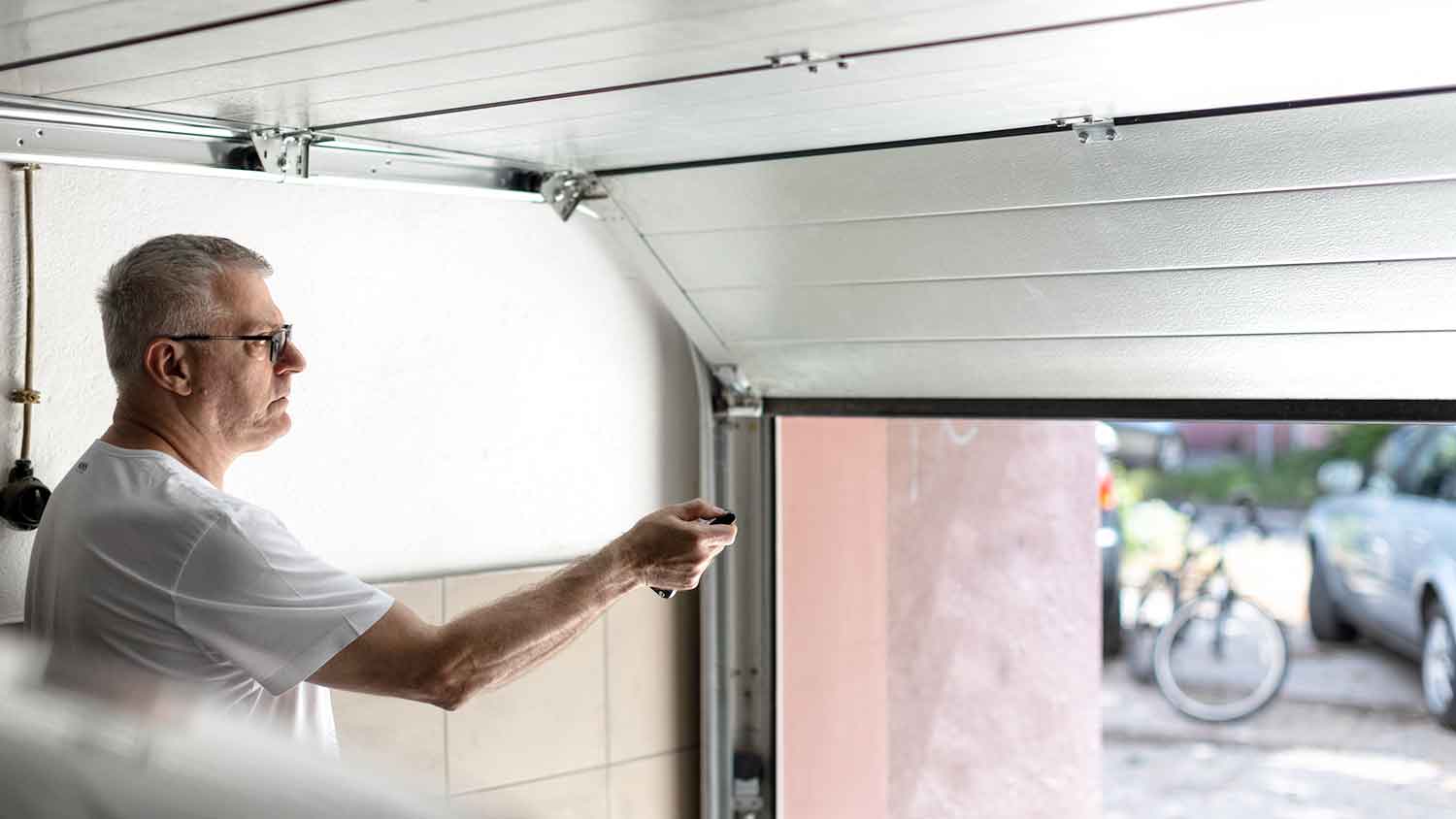 Man using remote control to close garage door