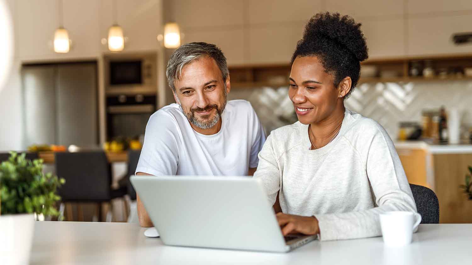 Couple using laptop at home