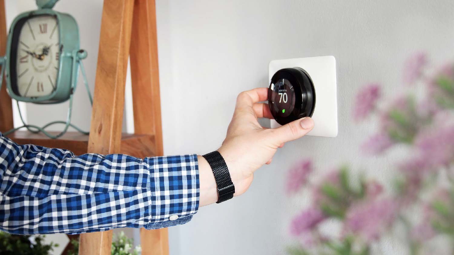 A man adjusting the thermostat
