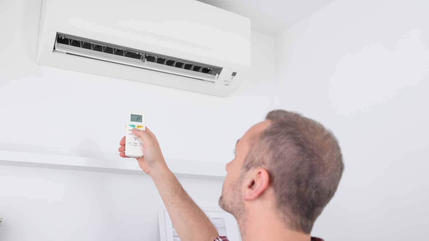 Man turning on AC unit