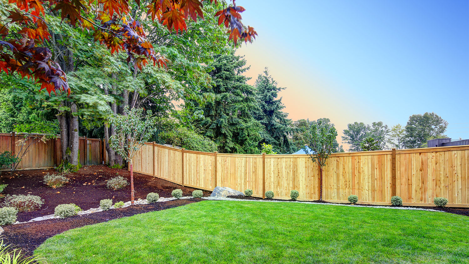 beautiful fenced backyard with planting beds