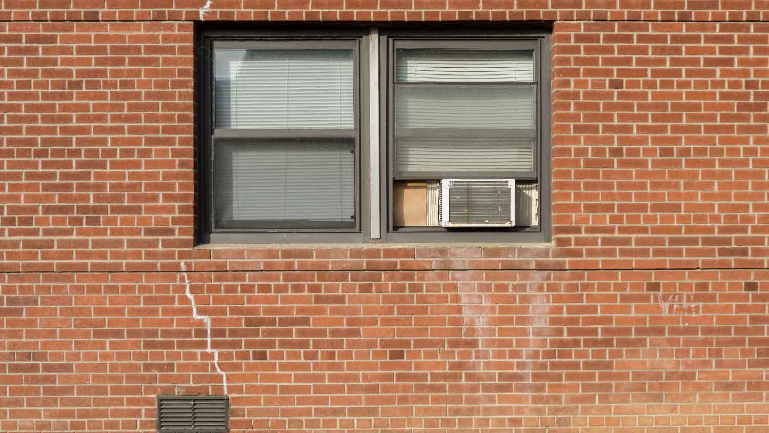 Exterior shot of a window AC on a red brick house