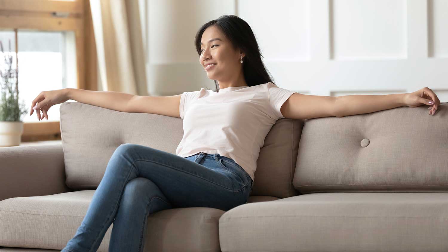 Woman sitting on the couch enjoying ac at home