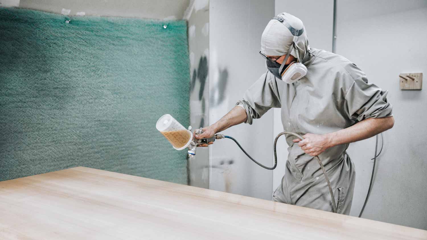 Carpenter varnishing wooden panel