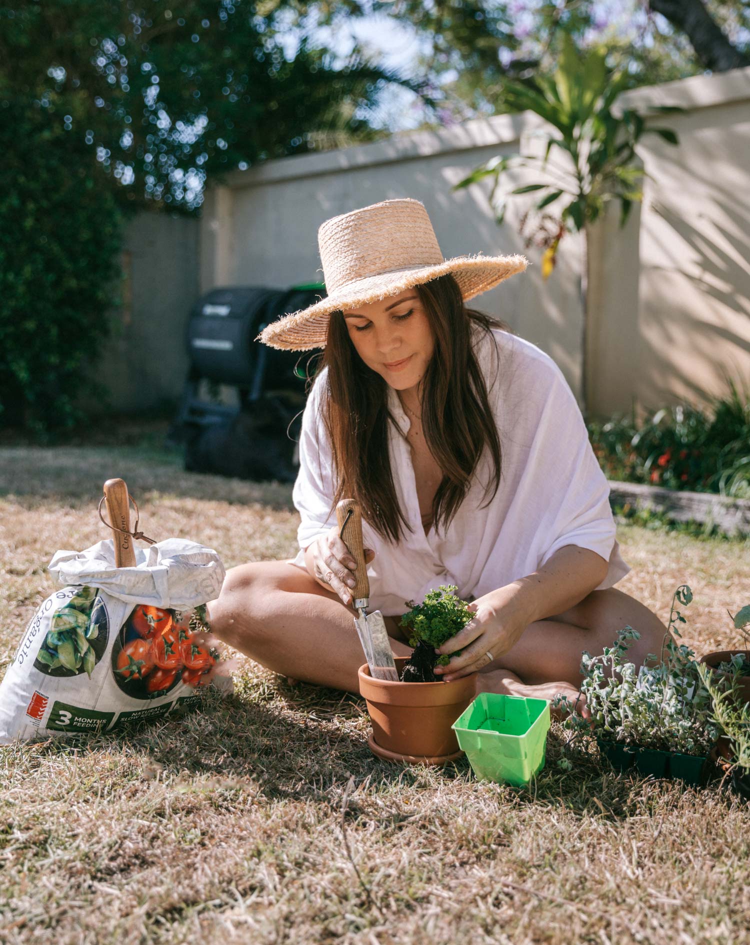 Kia sitting down and potting a plant