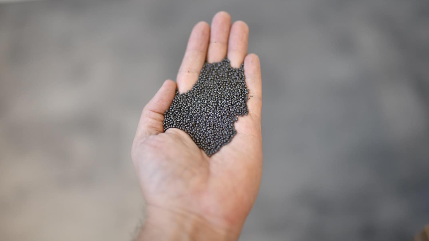 steel grits in the palm of someones hand