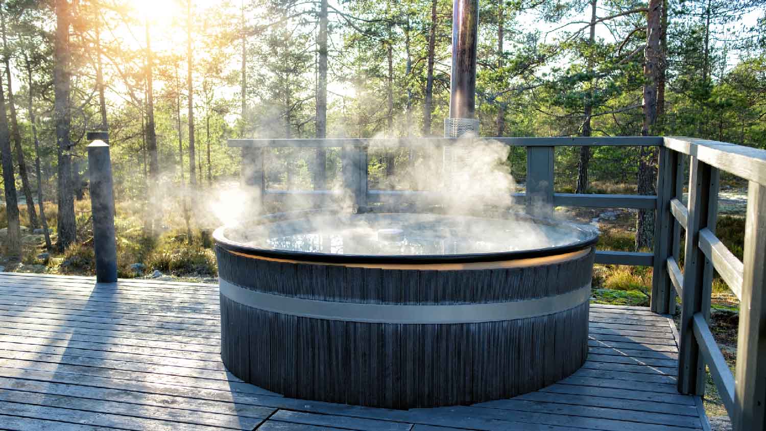 A hot tub on a deck looking at a forest