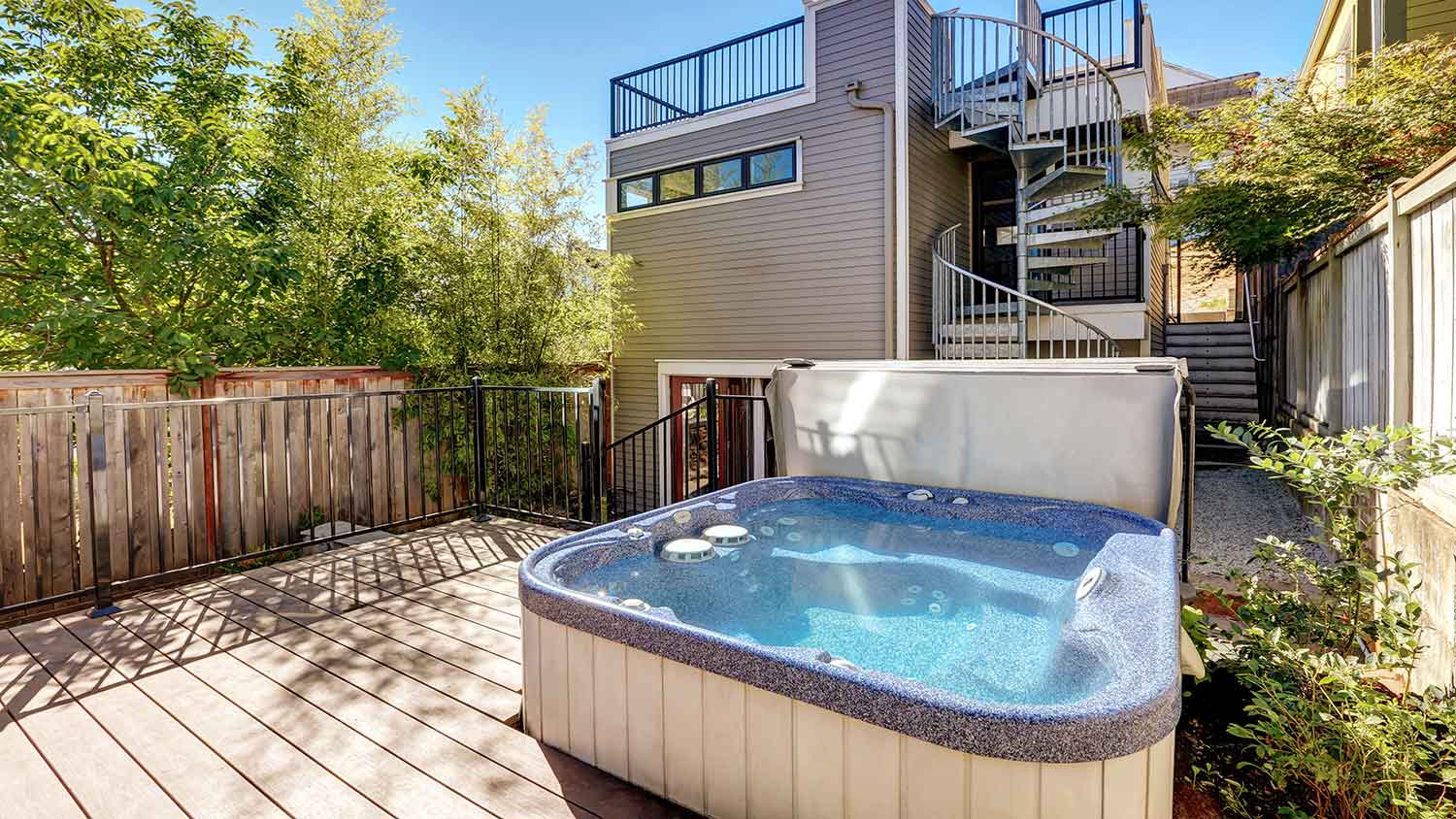 House backyard with deck and a hot tub