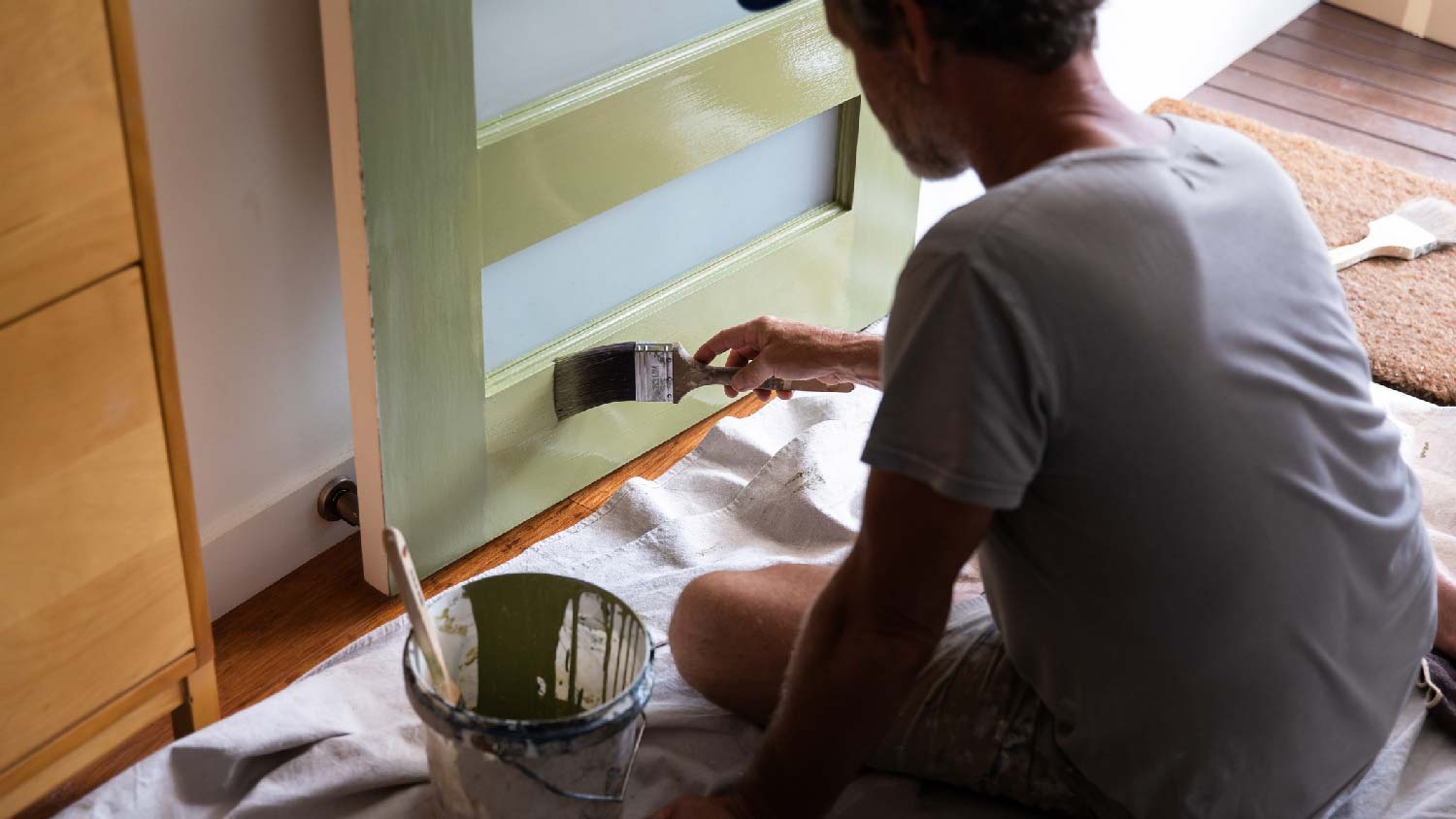 A man painting a front door with a brush
