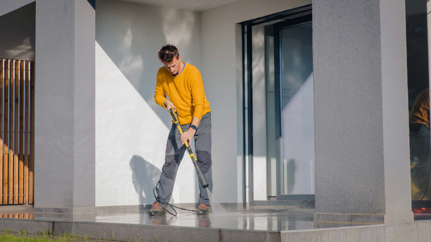 A person power washing the patio